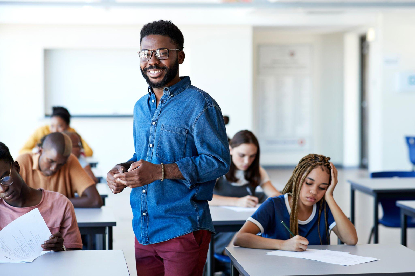 https://www.gettyimages.com/detail/photo/smiling-supervisor-amidst-students-writing-exam-royalty-free-image/1171160396?phrase=class%20teacher&adppopup=true